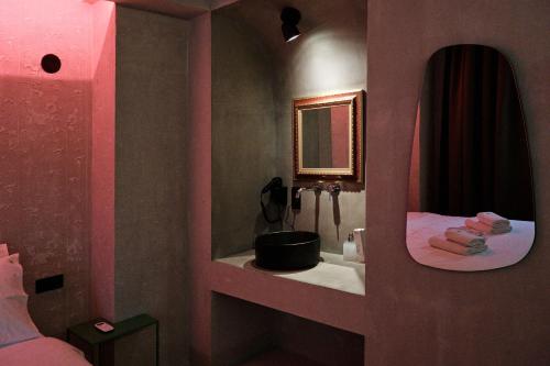 塞萨洛尼基Paradox的粉红色的浴室设有水槽和镜子