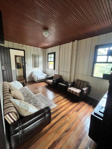 SiderópolisMorada Ignese的客厅配有皮革家具和木地板
