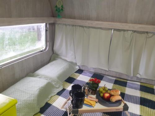 乌巴图巴Traillertuba Yaveh的一张桌子,上面放着一个食物托盘,放在大篷车里