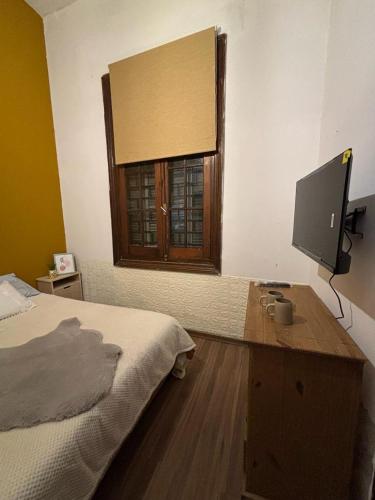 蒙得维的亚Expreso terminal的一间卧室配有一张床和一张书桌及电视