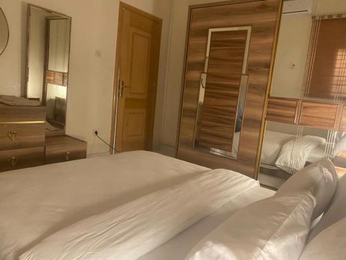 努瓦克肖特Nouakchott INN的卧室配有一张白色大床和镜子