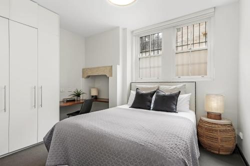 悉尼Balmain Wharf 1 bedroom Apartments的白色卧室配有床和书桌