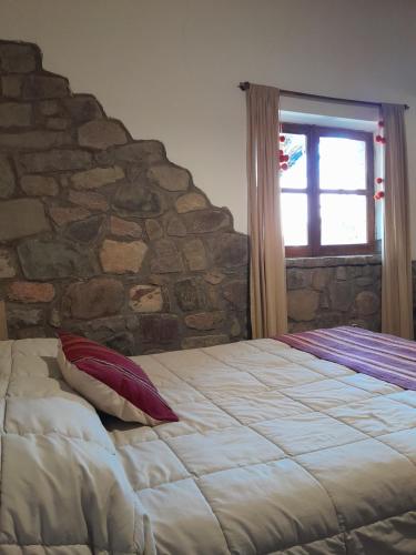 蒂尔卡拉La Casa del Indio的石墙房间内的一张床位