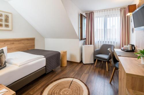 埃斯林根Neo Hotel Linde Esslingen的配有一张床和一张书桌的酒店客房