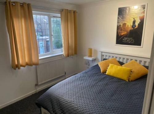 沃特福德Spacious 5 Bedroom House- Harry potter world & London的一间卧室配有一张带两个黄色枕头的床