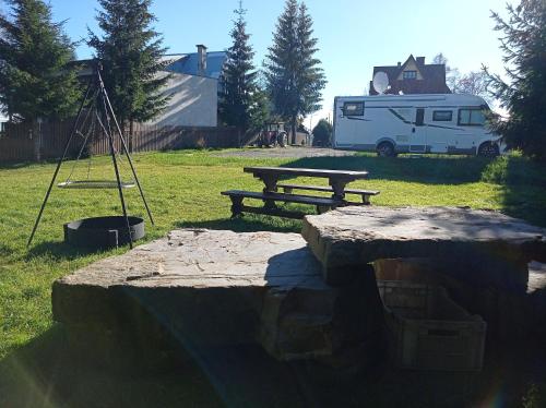 布科维纳-塔钱斯卡Tatrzański Camper Park- parcele kamperowe的野餐桌和田野长凳