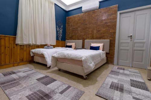开罗Villa Khufu Pyramids Inn的卧室设有两张床铺和蓝色的墙壁