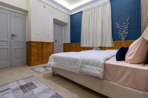 开罗Villa Khufu Pyramids Inn的一间卧室设有一张床和蓝色的墙壁