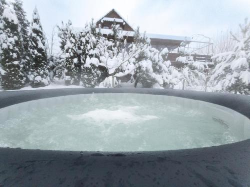 SablówkaGórski Azyl w Soblówce的房屋前的雪覆盖的热水浴池