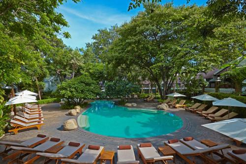 北芭堤雅兀兰酒店芭堤雅度假村的一个带椅子和遮阳伞的游泳池