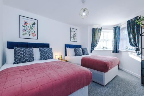 考文垂The Consort Serviced Apartment Coventry的一间卧室设有两张床和窗户。