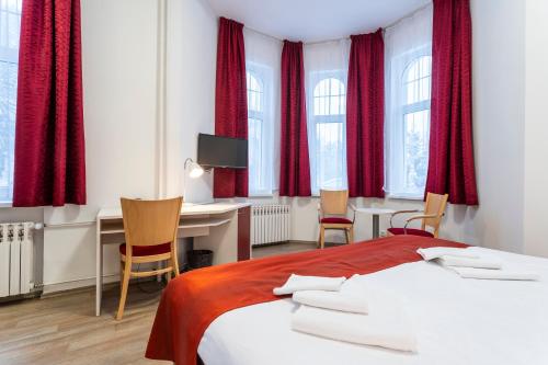 亚希莫夫Hotel Dagmar的一间卧室配有红色窗帘、书桌和一张床