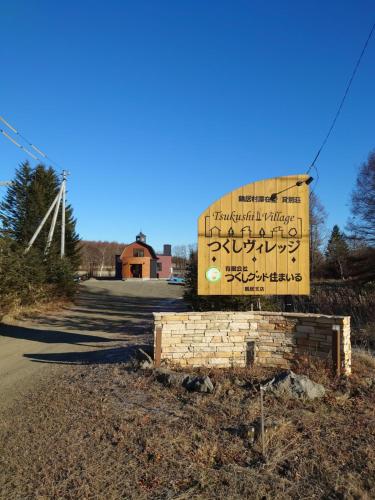 鹤居村Tsukushi Village的一座教堂的标志,有风车的背景