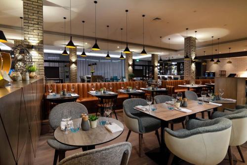 阿宾登Courtyard by Marriott Oxford South的一间带桌椅的餐厅和一间酒吧