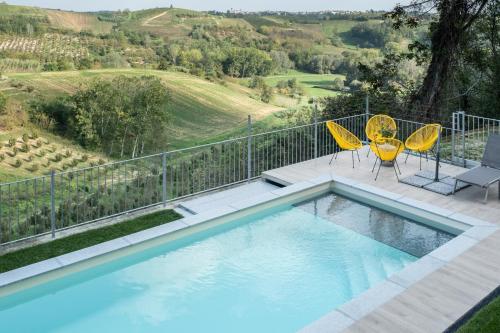 ScurzolengoCasa Verrua的一个带2把黄色椅子的游泳池和一个美景阳台