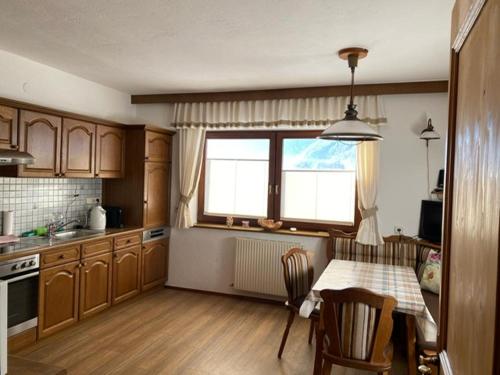 朗根费尔德Haus Reichlas的厨房配有桌椅和窗户。