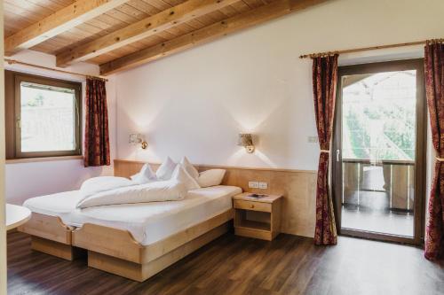拉古多Thalguter - Rooms & Breakfast的卧室配有白色的床和窗户。