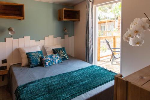 乐巴凯尔斯Camping L'Oasis et California的一间卧室配有一张带白色床头板的床