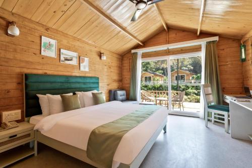 丹德利Stone Wood Jungle Resort, Dandeli的一间卧室设有一张大床和一个窗户。