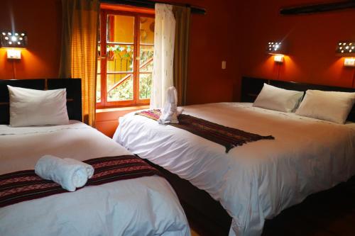 奥兰太坦波维拉斯旅馆的一间卧室设有两张带白色床单的床和窗户。