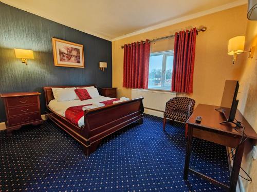 罗瑟勒姆Carlton Park Hotel Rotherham的配有一张床和一张书桌的酒店客房
