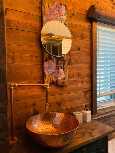 OrmstownEco Lodge Bûcheron Bergère的一间带铜制水槽和镜子的浴室