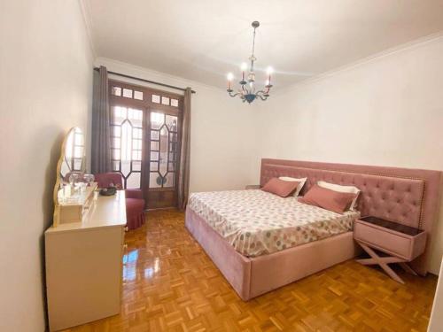 GH Odivelas - Quartos em Casa com Bilhar!的一间卧室配有一张床、一张桌子和一个吊灯。
