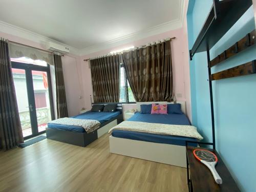 北宁Quanho Villa的卧室设有两张床,拥有蓝色和粉红色的墙壁