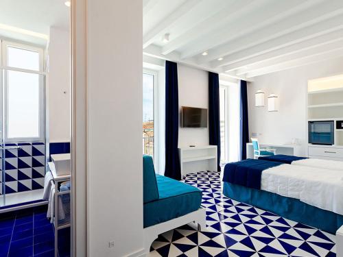 索伦托Maison Blu - Intimate GuestHouse的配有一张床和一张书桌的酒店客房