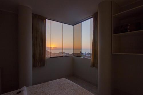伊洛Raissa Hotel的客房设有可欣赏日落美景的窗户。