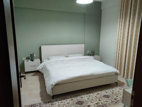 培拉特City Center Apartment的一间卧室配有一张带白色床单的大床