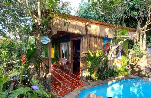 GiganteVilla Sonia Eco-Hostel的小屋前方设有游泳池