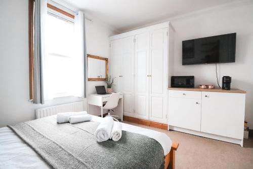 伦敦Fulham Rooms的一间卧室配有带毛巾的床