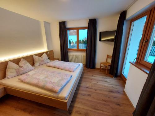 圣坎迪朵Appartements Schäfer的一间卧室设有一张床和两个窗户。