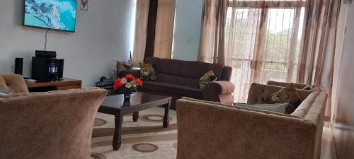 蒙巴萨SEBULENI LUXURY HOMESTAY - WALK TO NYALI BEACH Mombasa的客厅配有沙发、两把椅子和一张桌子