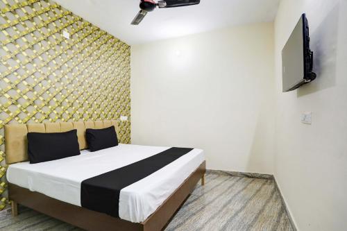 加济阿巴德OYO Flagship Hotel Blue Diamond的一间卧室配有一张床,墙上配有电视