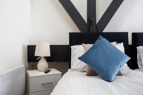 布雷得佛Large Duplex Penthouse Apartment的一间卧室配有一张带蓝色枕头的床