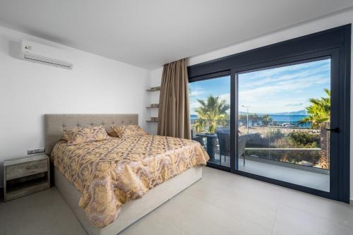 克雷马斯蒂Penélope Beachfront Villa的一间卧室设有一张床和一个大窗户