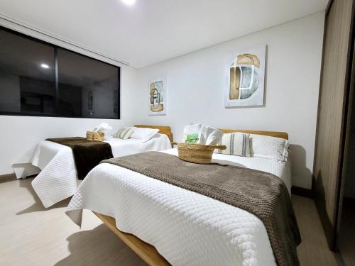 麦德林New Luxury 3 Bedroom Apartment in Great Area.的酒店客房设有两张床和大窗户。