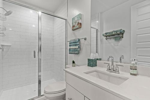凤凰城AT YOUR SERVICE - Modern Amenities, Urban Location, Sophisticated Style的白色的浴室设有卫生间和水槽。