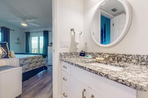 圣徒皮特海滩Gulf Strand Resort 308的一间带水槽和镜子的浴室以及一张床