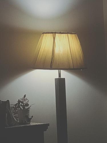 木尔坦Motel Ambassador Multan的坐在墙上桌子上的一盏灯