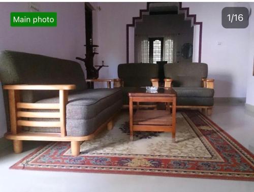 马迪凯里Dhruva Homestay的客厅配有两张沙发和一张咖啡桌