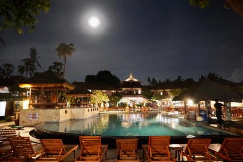塞米亚克Galayanee’s Resort Apartment的夜间游泳池,带椅子和月亮