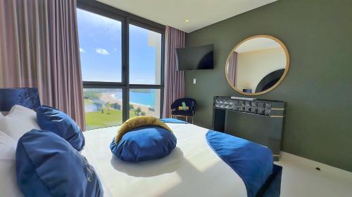 CupecoyMullet Bay Suites - Your Luxury Stay Awaits的一间卧室配有一张带蓝色枕头和镜子的床
