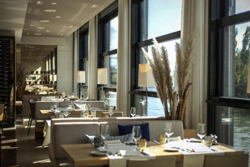 苏黎世STAYY The River - contactless check-in的餐厅设有桌椅和大窗户。