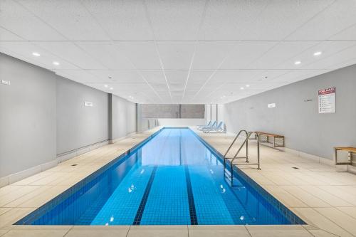 悉尼APX世界广场公寓式酒店的大楼内一个蓝色的大型游泳池