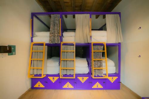 墨西哥城Viajero CDMX Centro Hostel的客房配有带毛巾的紫色双层床。