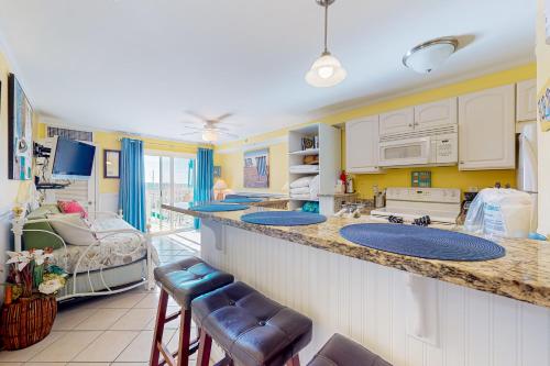 大洋城Makai 404的一个带两个水槽的厨房和一张位于客房内的床