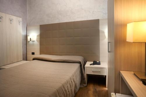 都灵嘉林佩缇酒店的一间小卧室,配有床和床头柜